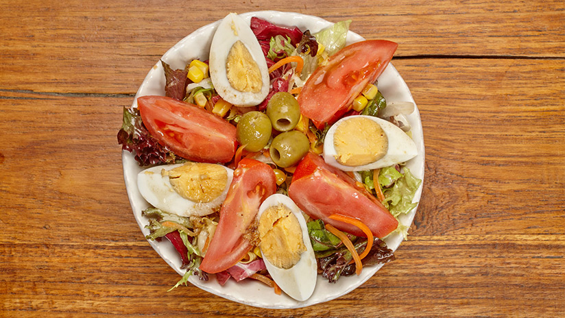 Ensalada mediterránea: Lechuga gourmet, tomate, huevo duro, zanahoria, olivas, maiz y vinagreta de frutos secos.