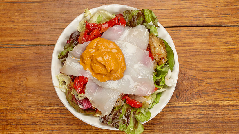 Ensalada de verduras asadas con bacalao, salsa romesco y lechuga gourmet.