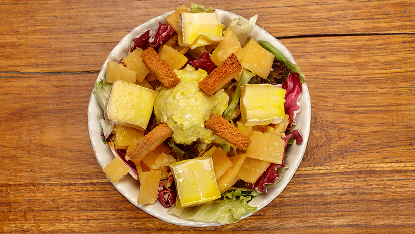 Ensalada de lechugas con surtido de quesos y tostones a la vinagreta dulce de mostaza.