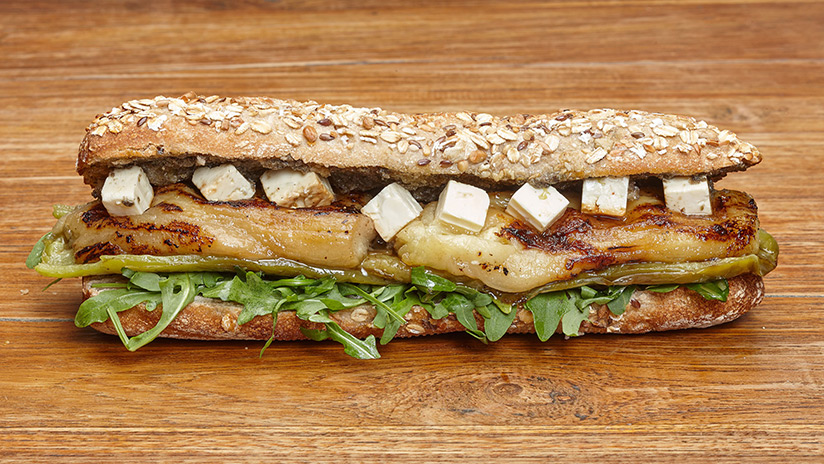 Bocadillo de Queso feta, berenjenas, pimientos asados, rúcula y salsa tapenade. Pan de semilla