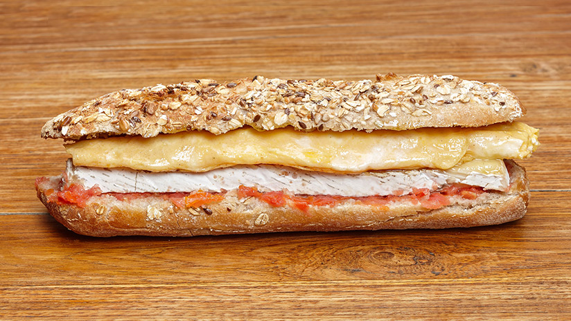 Bocadillo de tortilla francesa con queso brie y Pan de semilla con tomate.