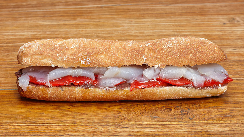 Bocadillo de bacalao marinado con paté de aceitunas y pimientos rojos.