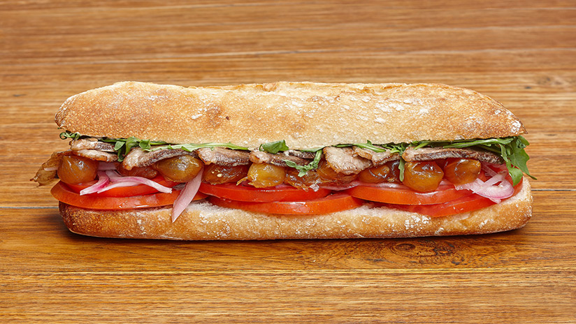 Bocadillo de pato asado, tomate, rúcula, pickles de cebollas y salsa boletus.